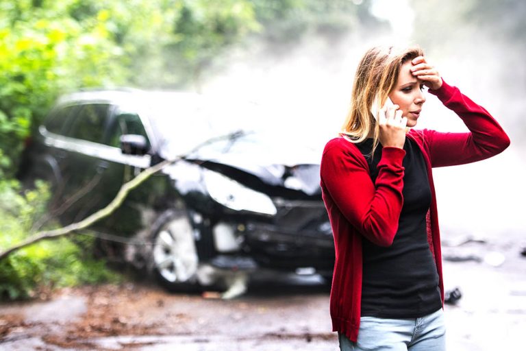 Carr Accident Woman with smartphone by the damaged car after a car accident making a phone call. car accident insurance claims
